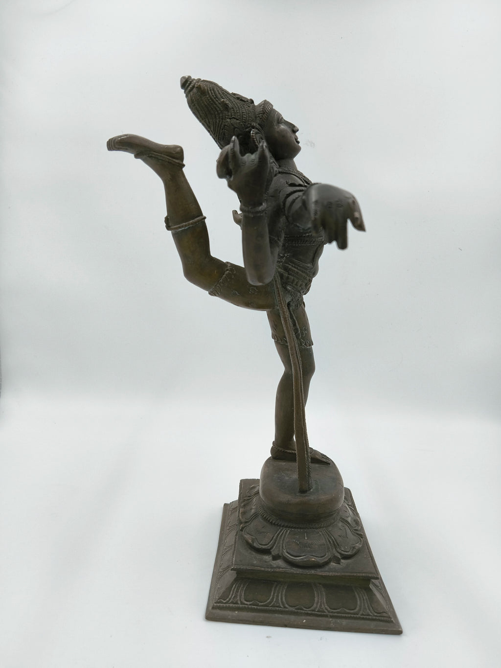 Side view of bronze Nataraja sculpture depicting dancing Shiva on ornate base