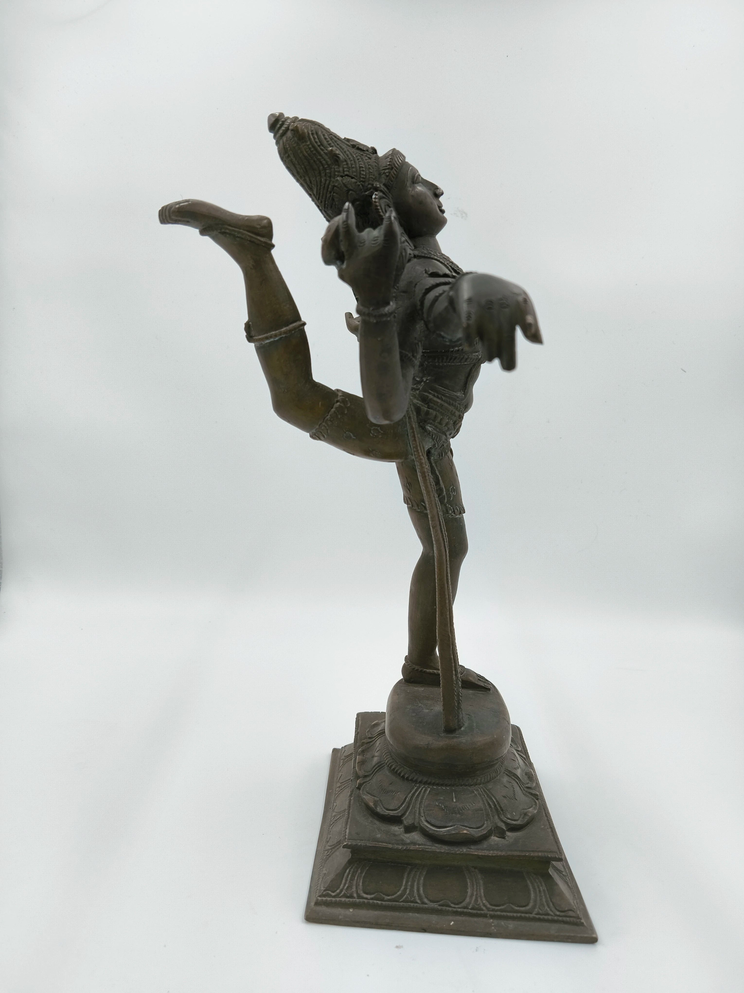 Side view of bronze Nataraja sculpture depicting dancing Shiva on ornate base