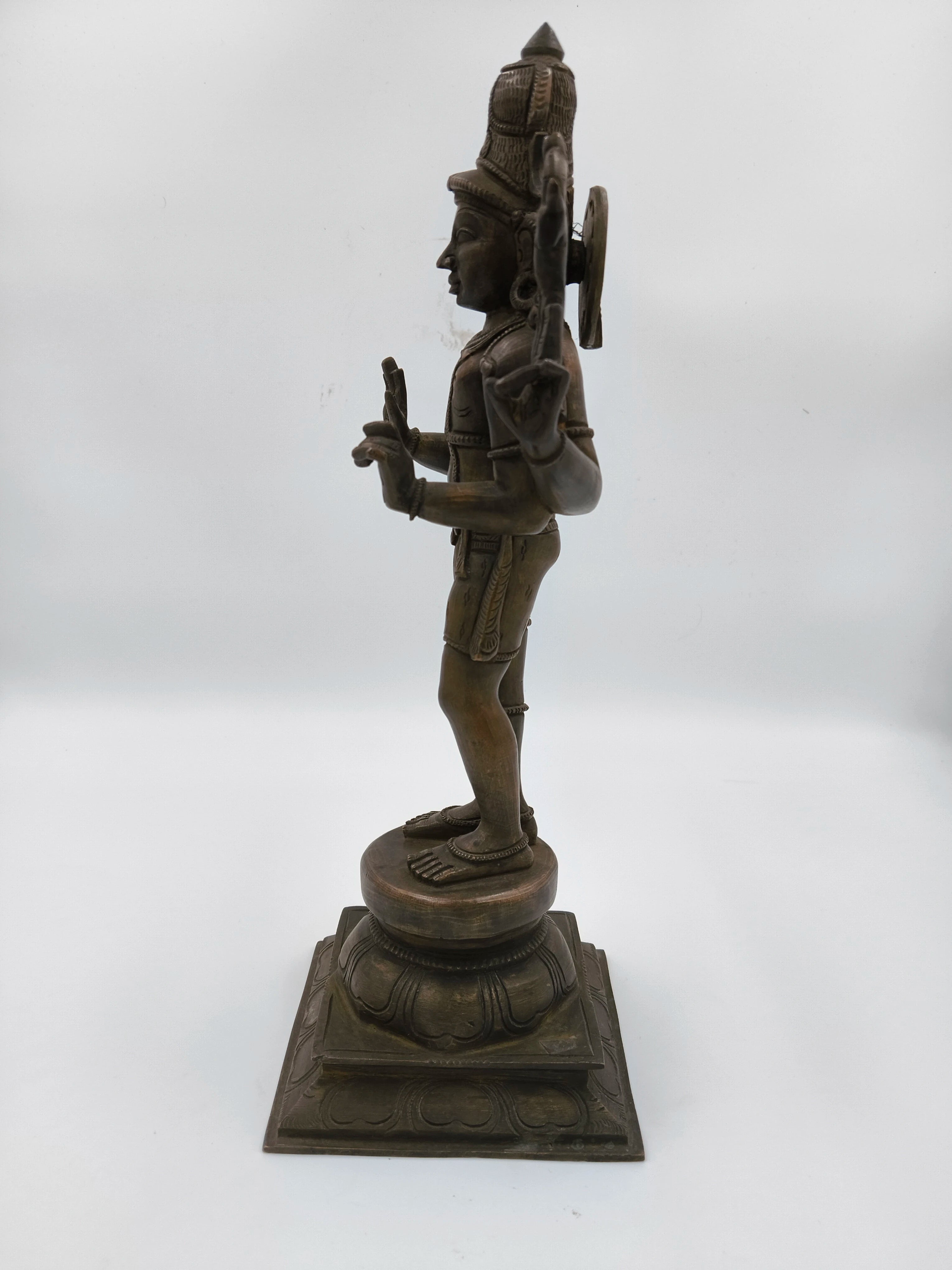 Side view of large bronze Shiva statue standing on intricately carved pedestal