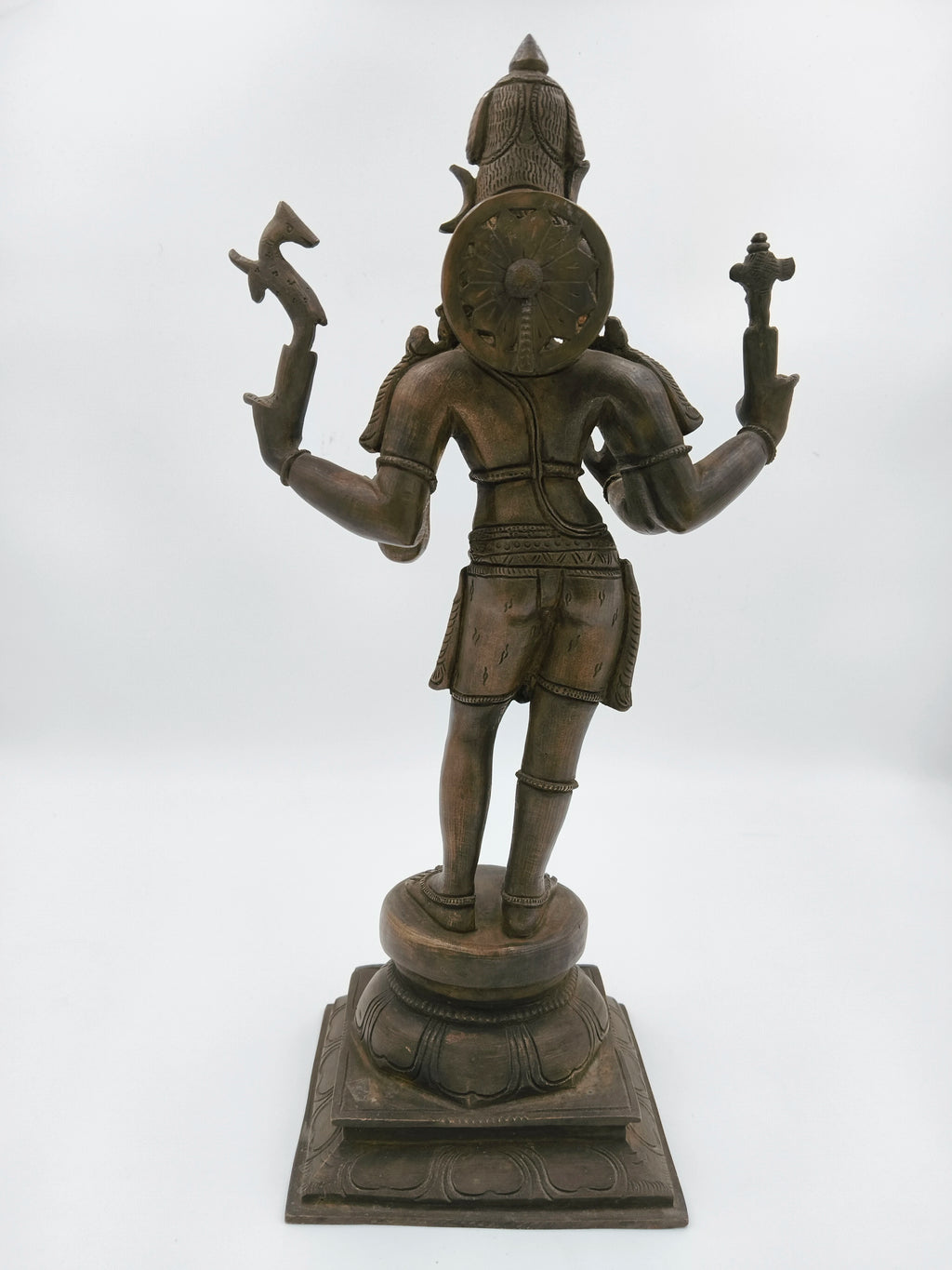 Back view of a large bronze Shiva sculpture standing on a decorative base