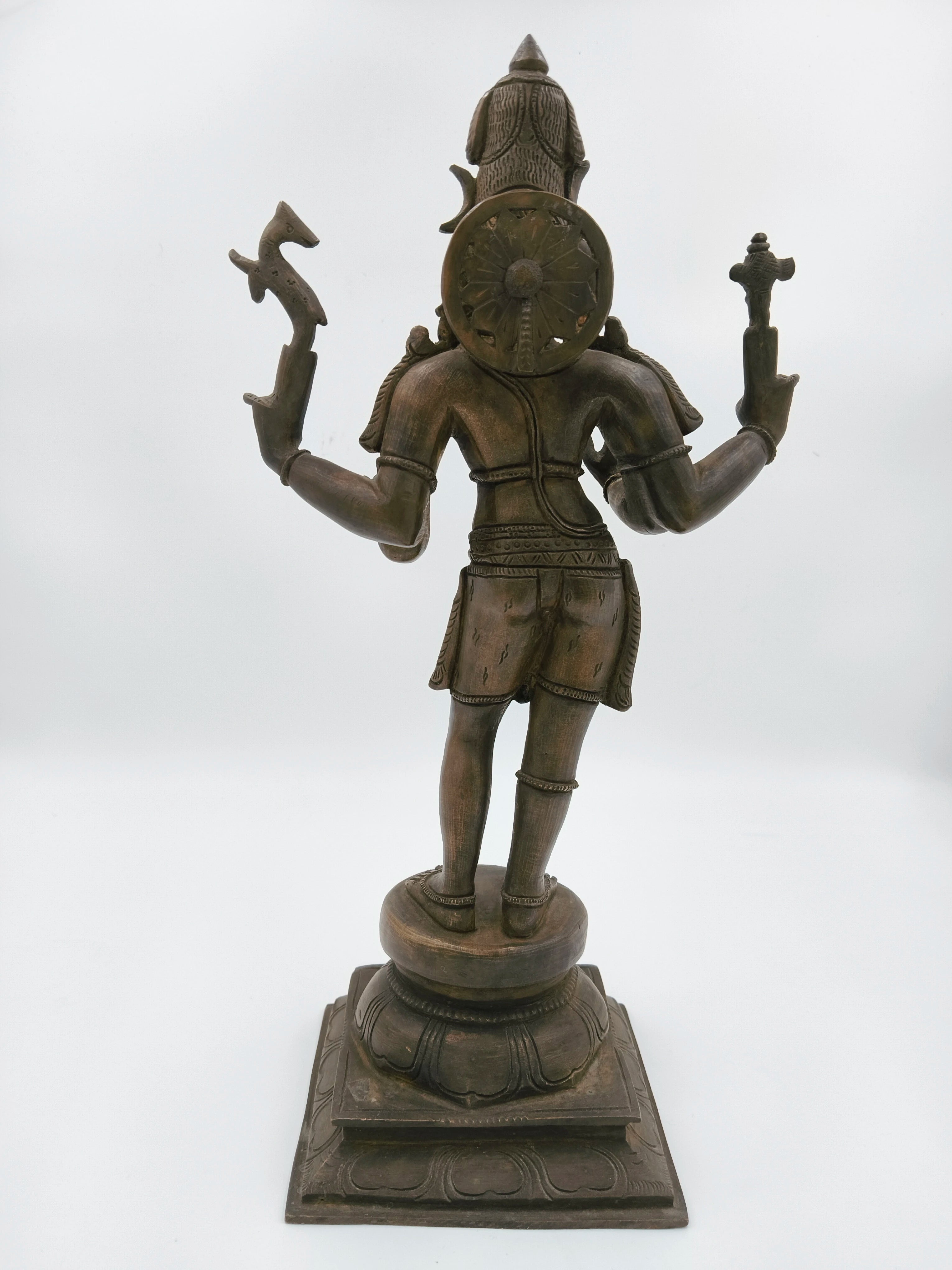 Back view of a large bronze Shiva sculpture standing on a decorative base