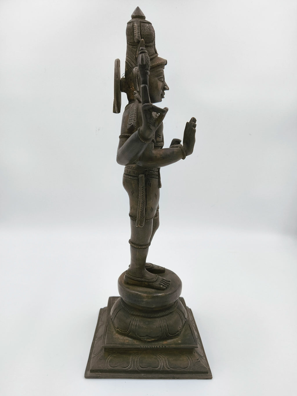 Side view of bronze statue of Shiva standing on a lotus pedestal
