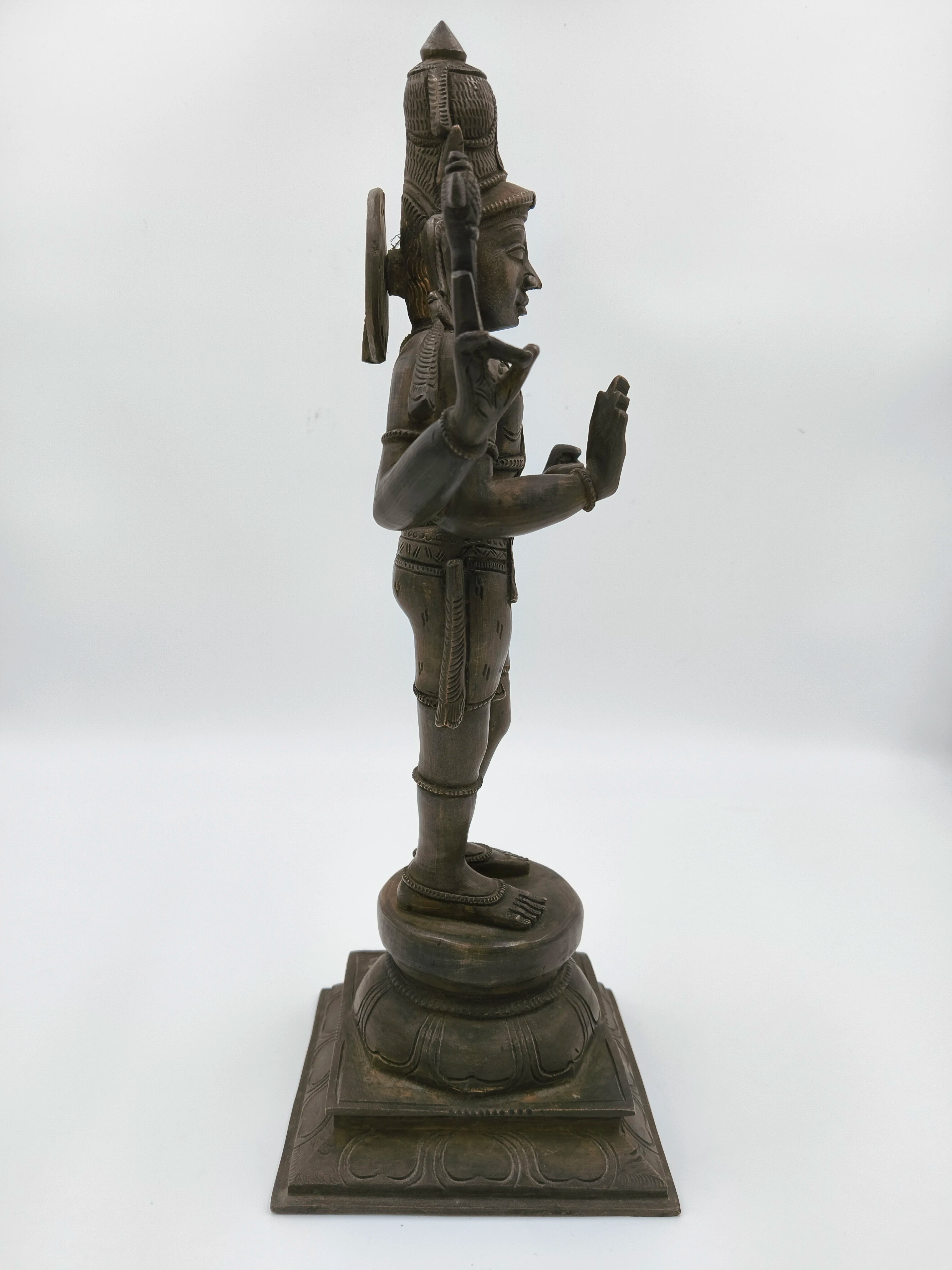 Side view of bronze statue of Shiva standing on a lotus pedestal
