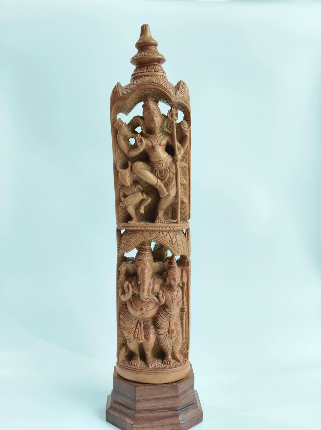 Tall sandalwood sculpture featuring Hindu gods Ganesh and Karthikaya on wooden base