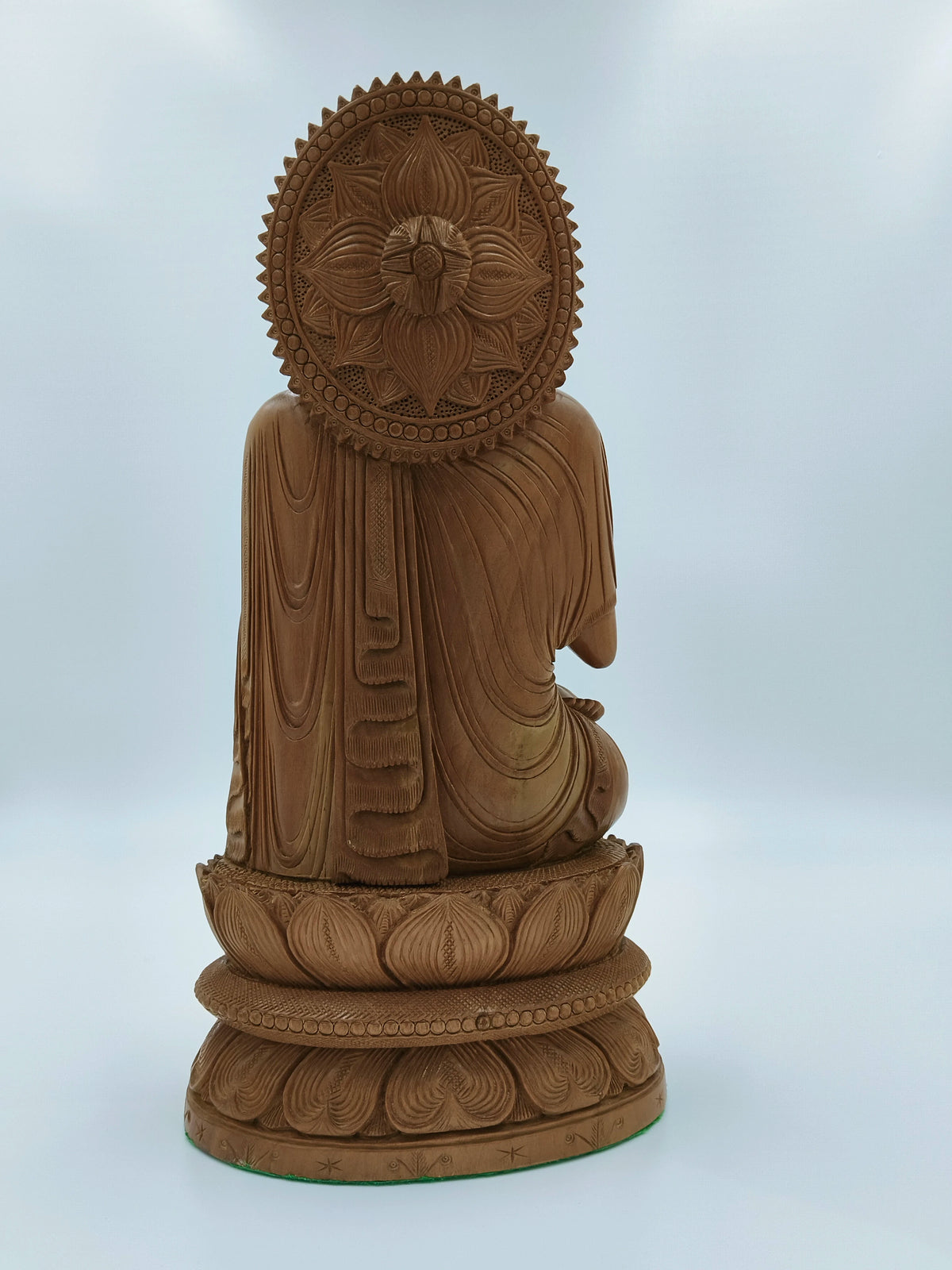 Back view of large handcrafted sandalwood Buddha statue with detailed lotus base