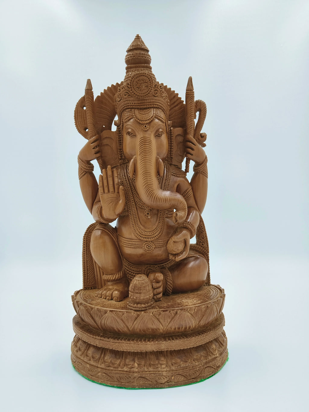 Large sandalwood carved Ganesh statue with intricate detailing, sitting on lotus pedestal