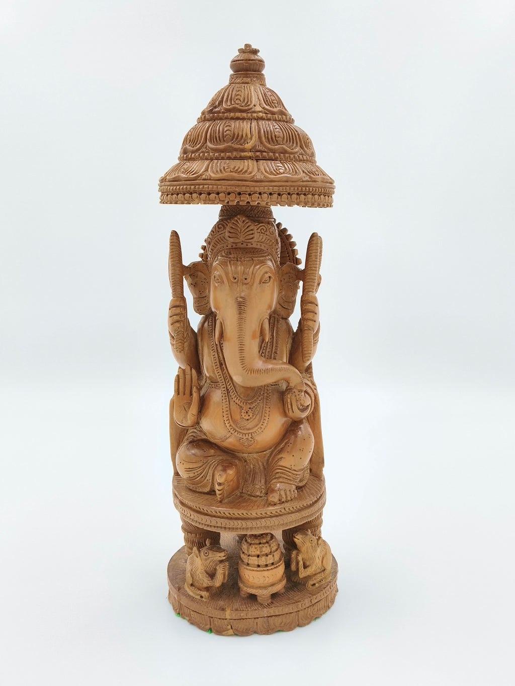Large sandalwood Ganesh idol seated under ornate carved canopy