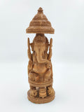 Large sandalwood Ganesh idol seated under ornate carved canopy