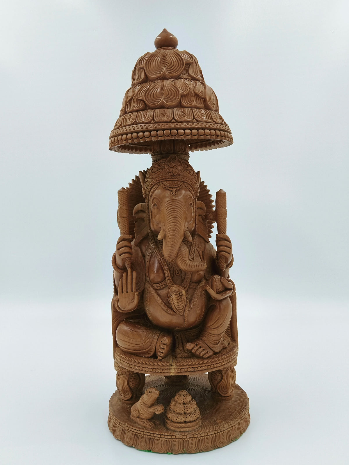 Sandalwood Ganesh idol seated on ornate throne with canopy and small mouse figurine