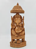 Large wooden sandalwood sculpture of Lord Ganesh under ornate canopy