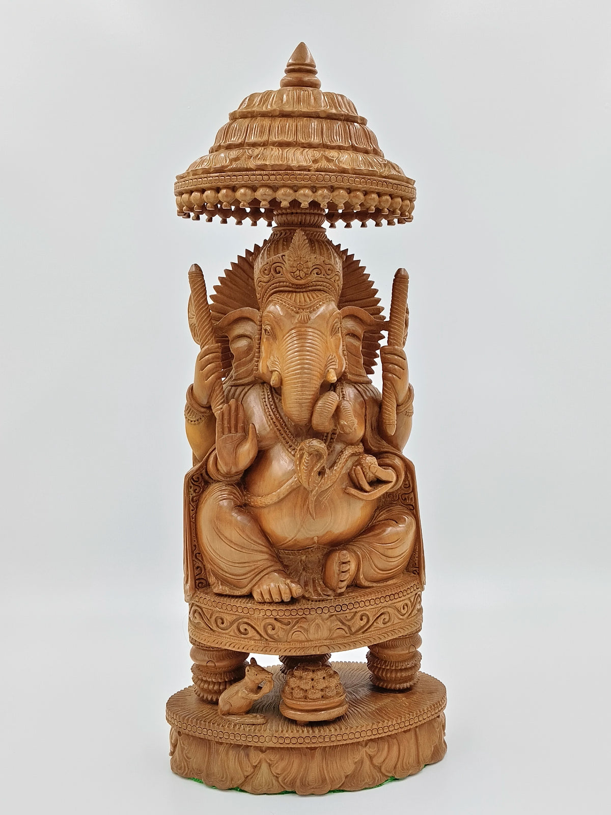 Large wooden sandalwood sculpture of Lord Ganesh under ornate canopy