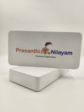 Wooden tabletop clock with Prashanthi Nilayam logo and text
