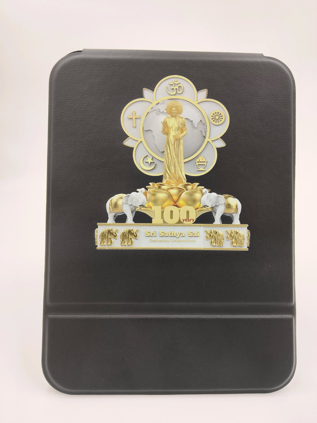 Black wooden board featuring Sri Sathya Sai Baba golden statue and centenary celebration emblem