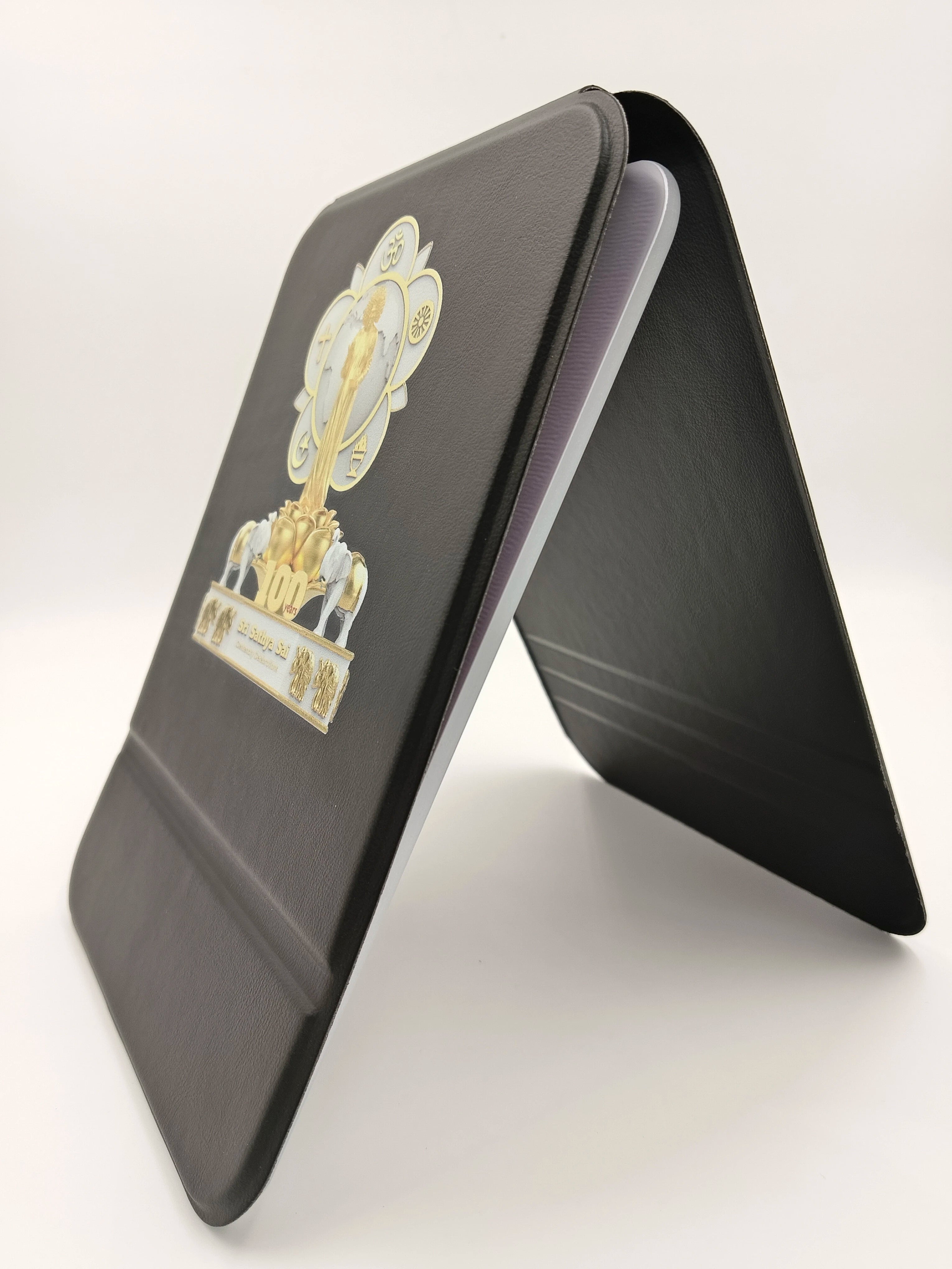 Black wooden board with Sri Sathya Sai Baba centenary celebration logo and symbols