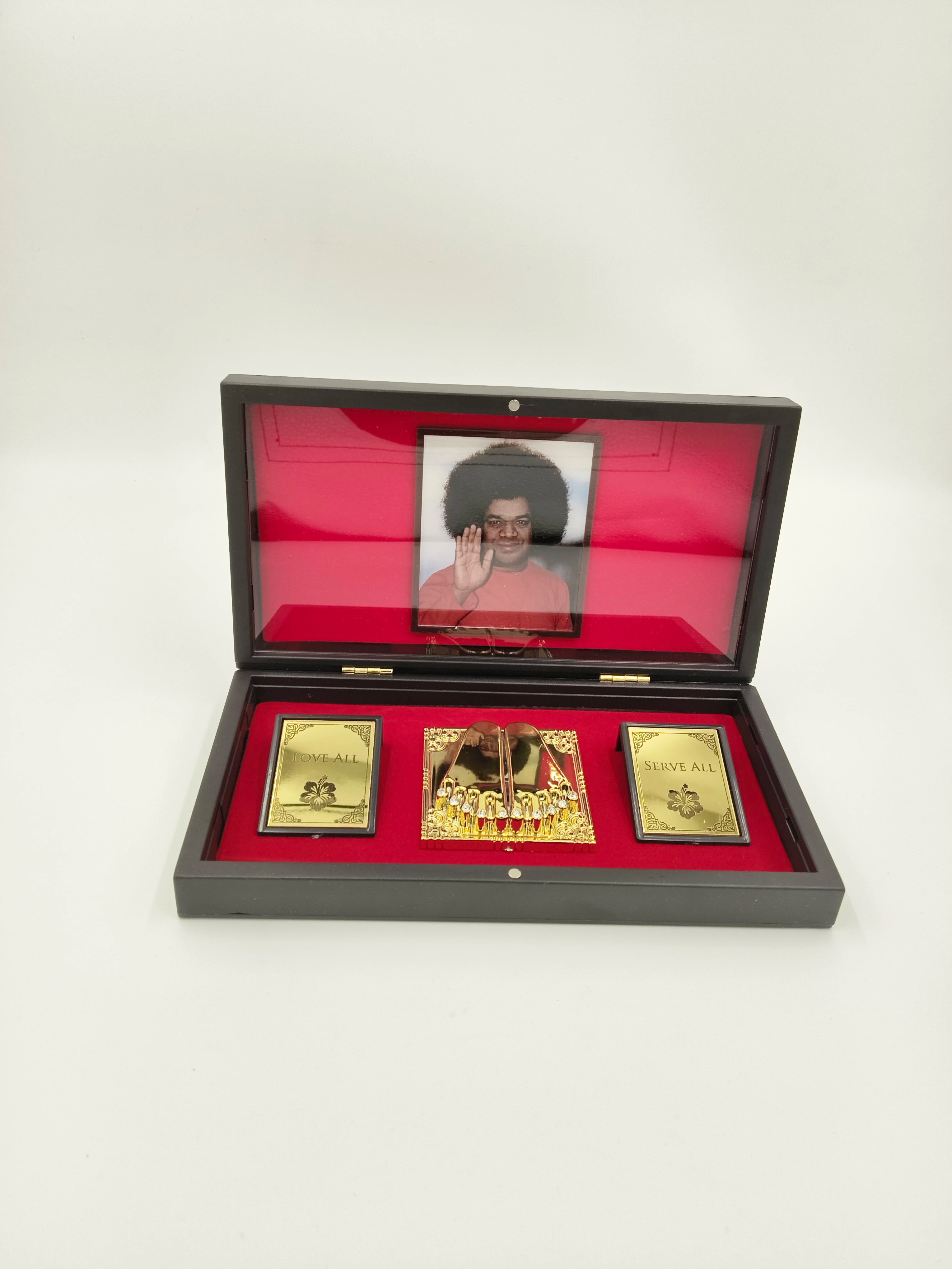 Compact Sri Sathya Sai Baba Paduka gold-colored sandals in a decorative wooden box with red interior and photograph
