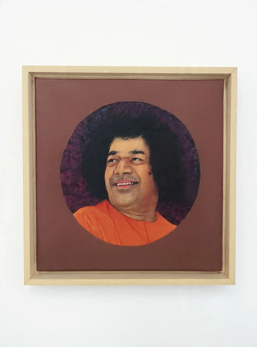 Framed oil painting portrait of Sai Baba with orange robe and dark curly hair