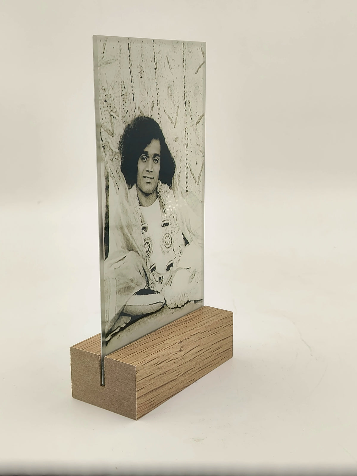 Glass photo display with wooden base featuring black and white portrait