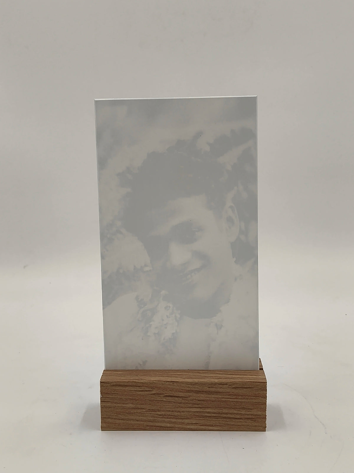 Large rectangular glass display with wooden base featuring engraved portrait