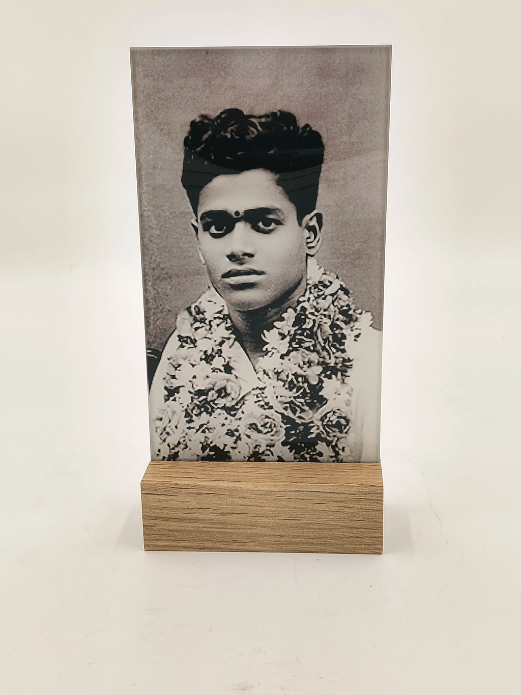 Glass photo display with wooden base showing a black and white portrait