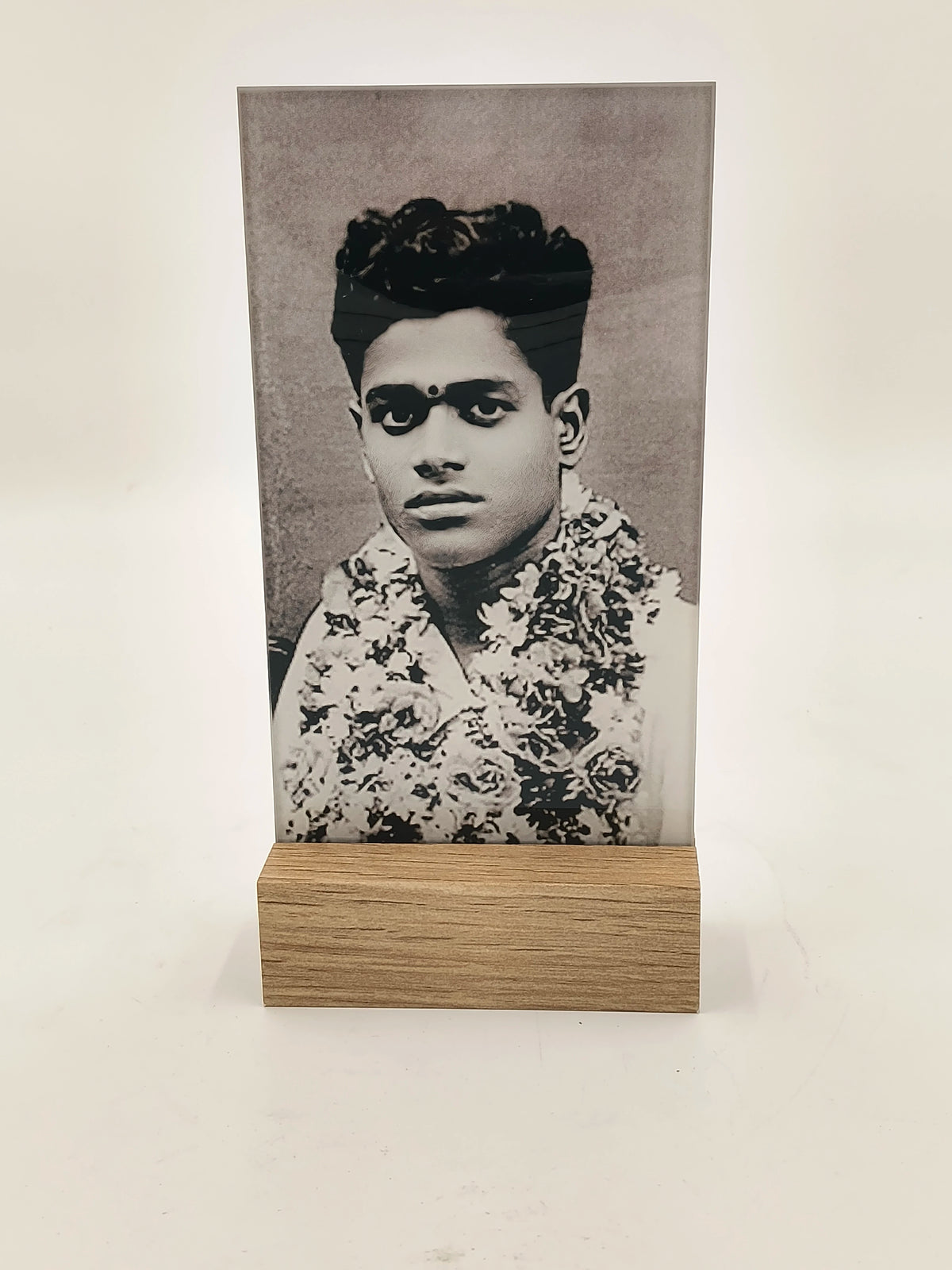 Glass photo display with wooden base showing a black and white portrait