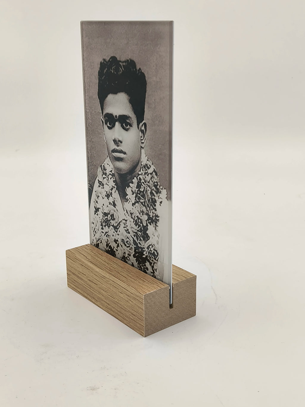 Large glass photo display panel held by wooden base, showing vintage portrait