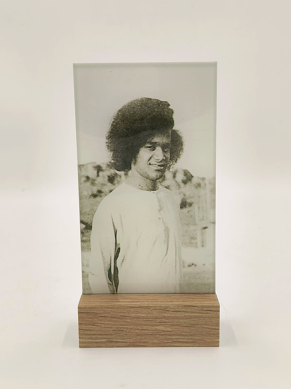 Glass and wood display plaque with black and white photo of a man in traditional clothing