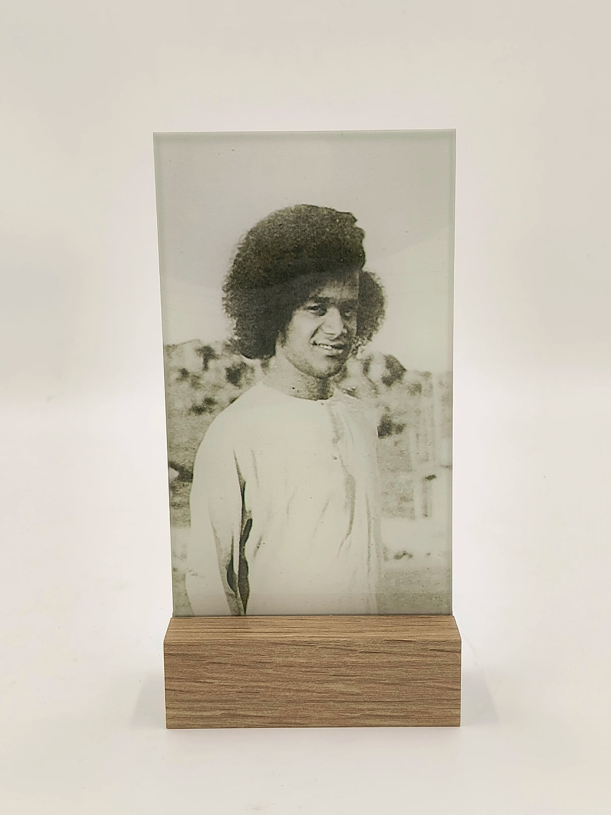 Glass and wood display plaque with black and white photo of a man in traditional clothing
