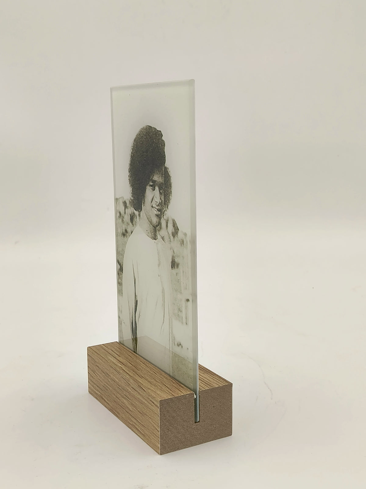 rectangular glass panel with black and white portrait held by wooden base