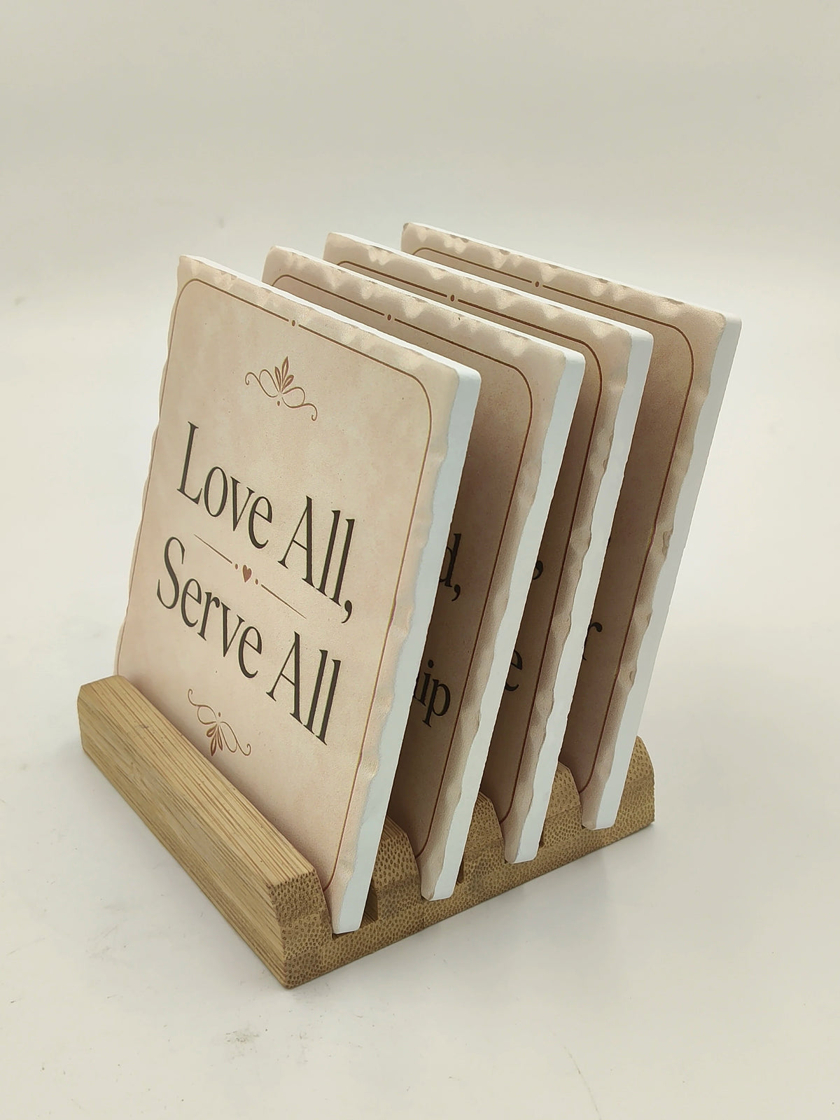 Set of ceramic coasters with inspirational quotes in a wooden holder