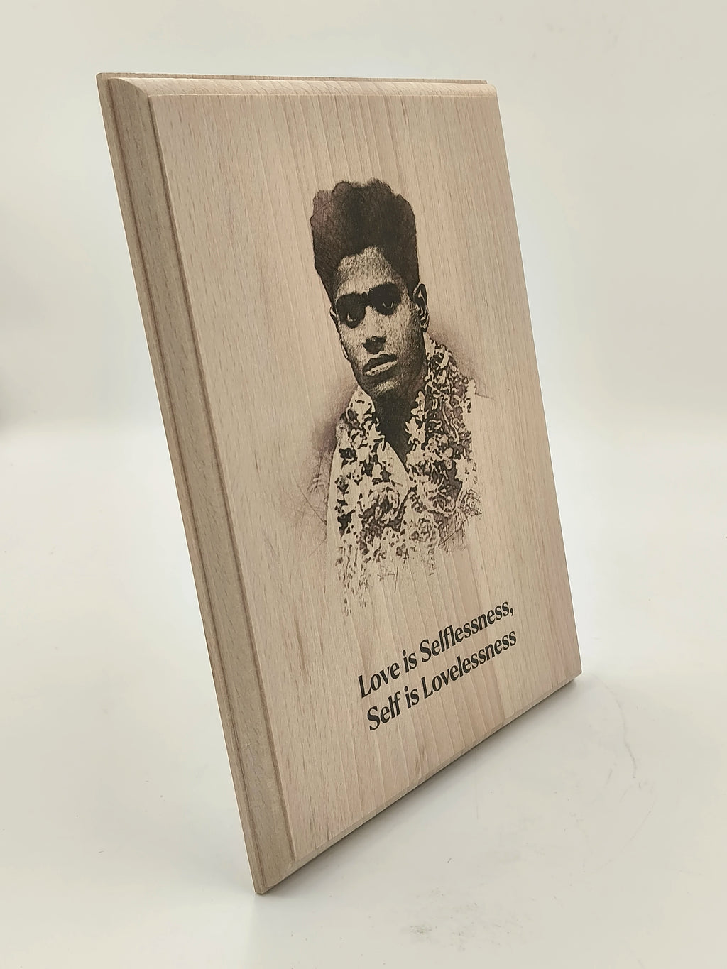 Wooden plaque with engraved portrait and inscription about love and selflessness
