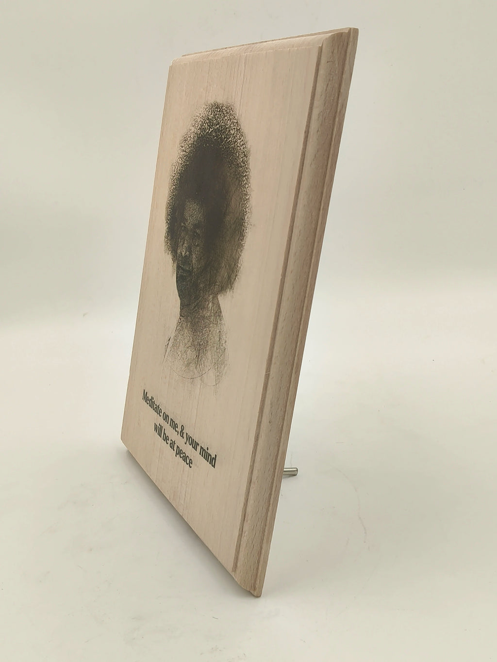 Side view of a large wooden plaque with a portrait and meditation quote