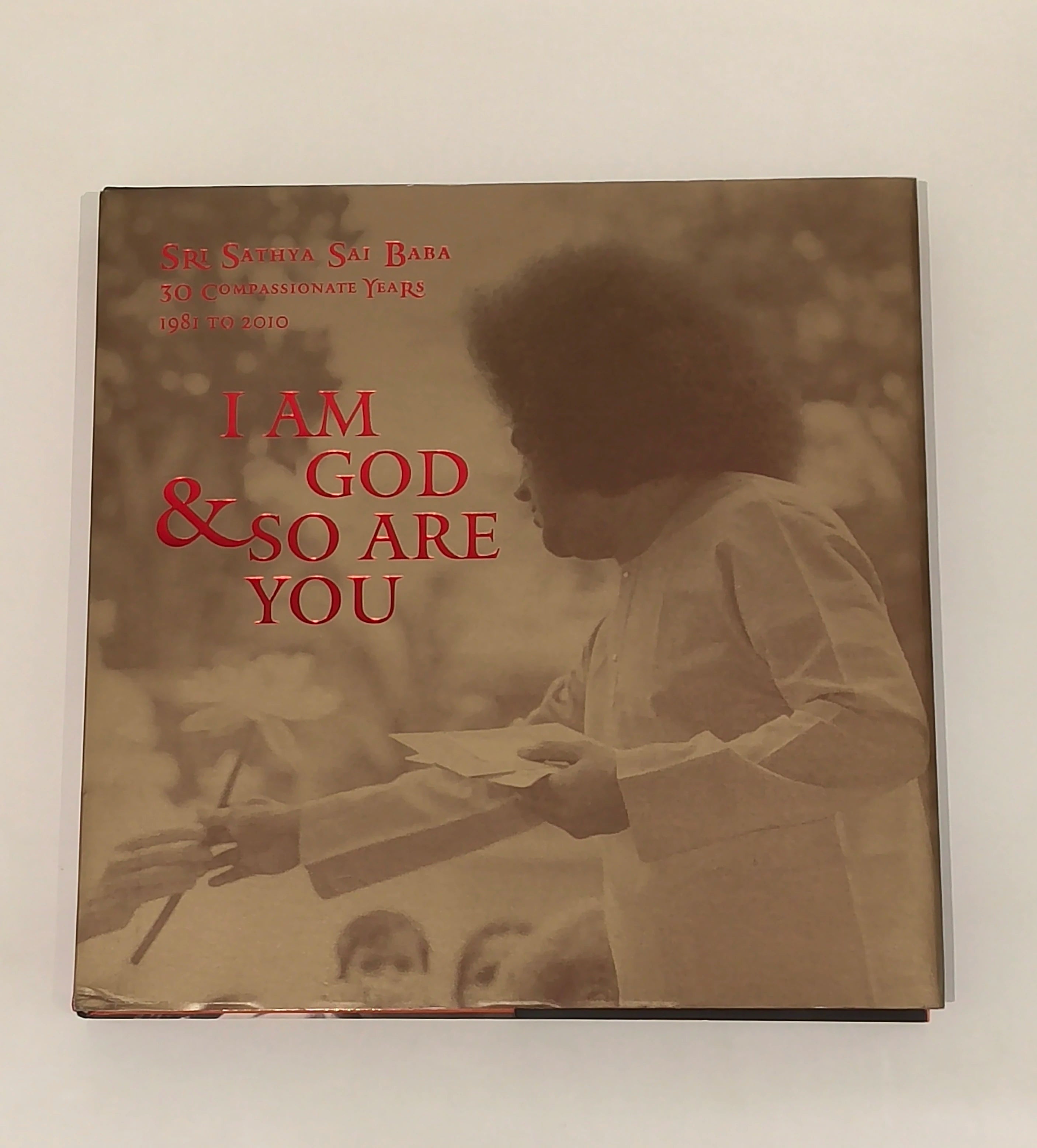 Hardbound book set titled I Am God & So Are You with sepia cover image