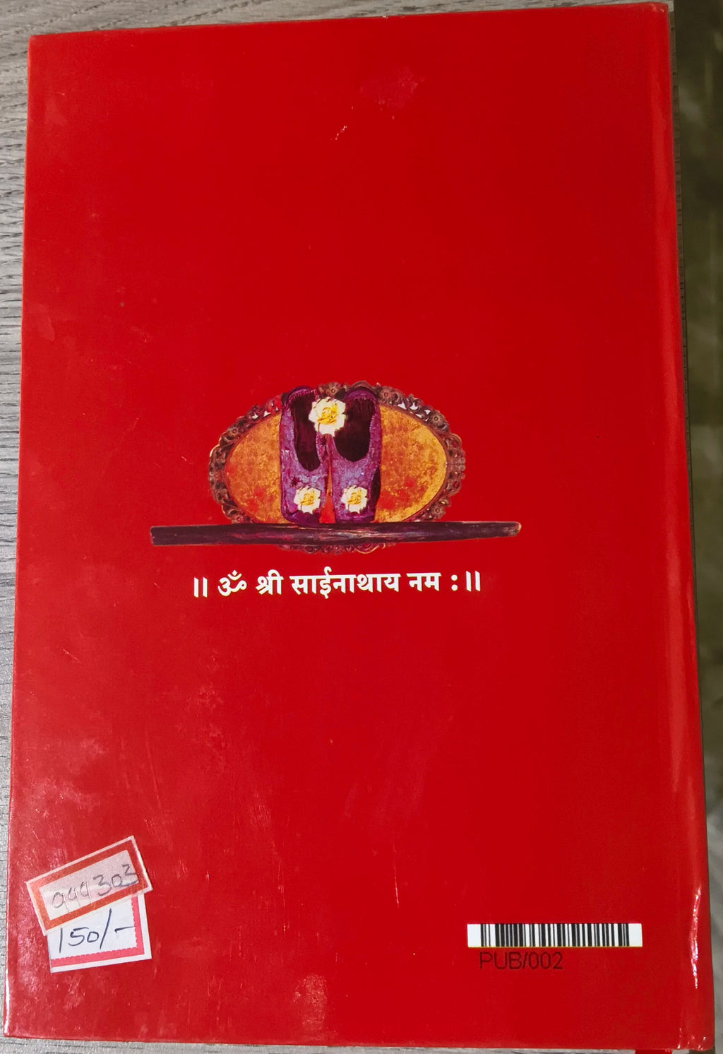 Back cover of Sri Sai Satcharitra Telugu paperback book with red background and religious symbol